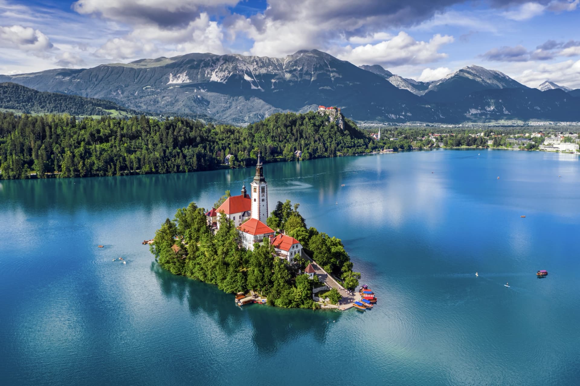 Church on island in Lake Bled with Julian Alps and castle on hill in background