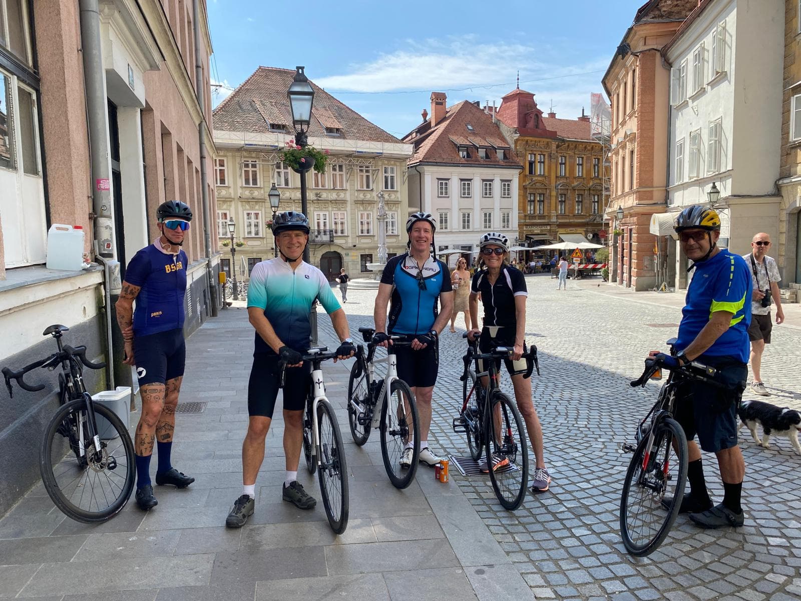 Cyclists with road bikes standing on cobblestone street in Ljubljana historic center