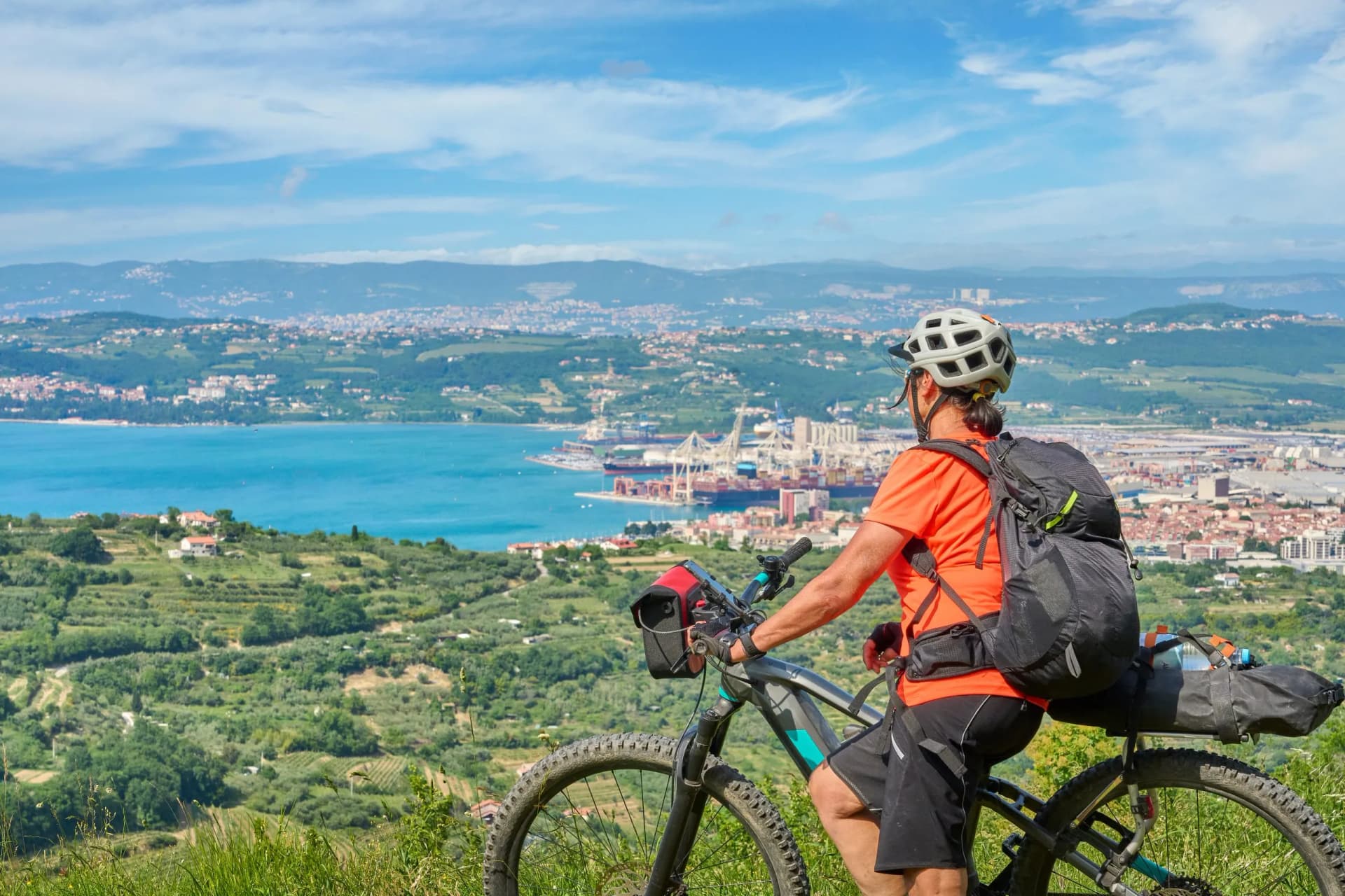 Mountain biker on tour overlooking Koper at Capodistria on the Slovenian Mediterranean coast.