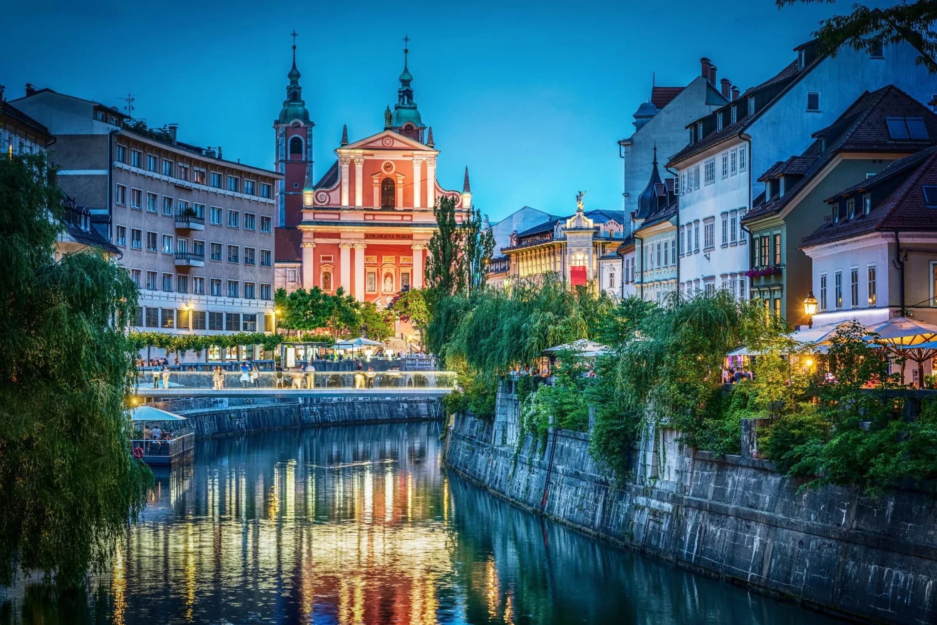 Evening view of the pink Franciscan Church and Ljubljanica River in Ljubljana, Slovenia.