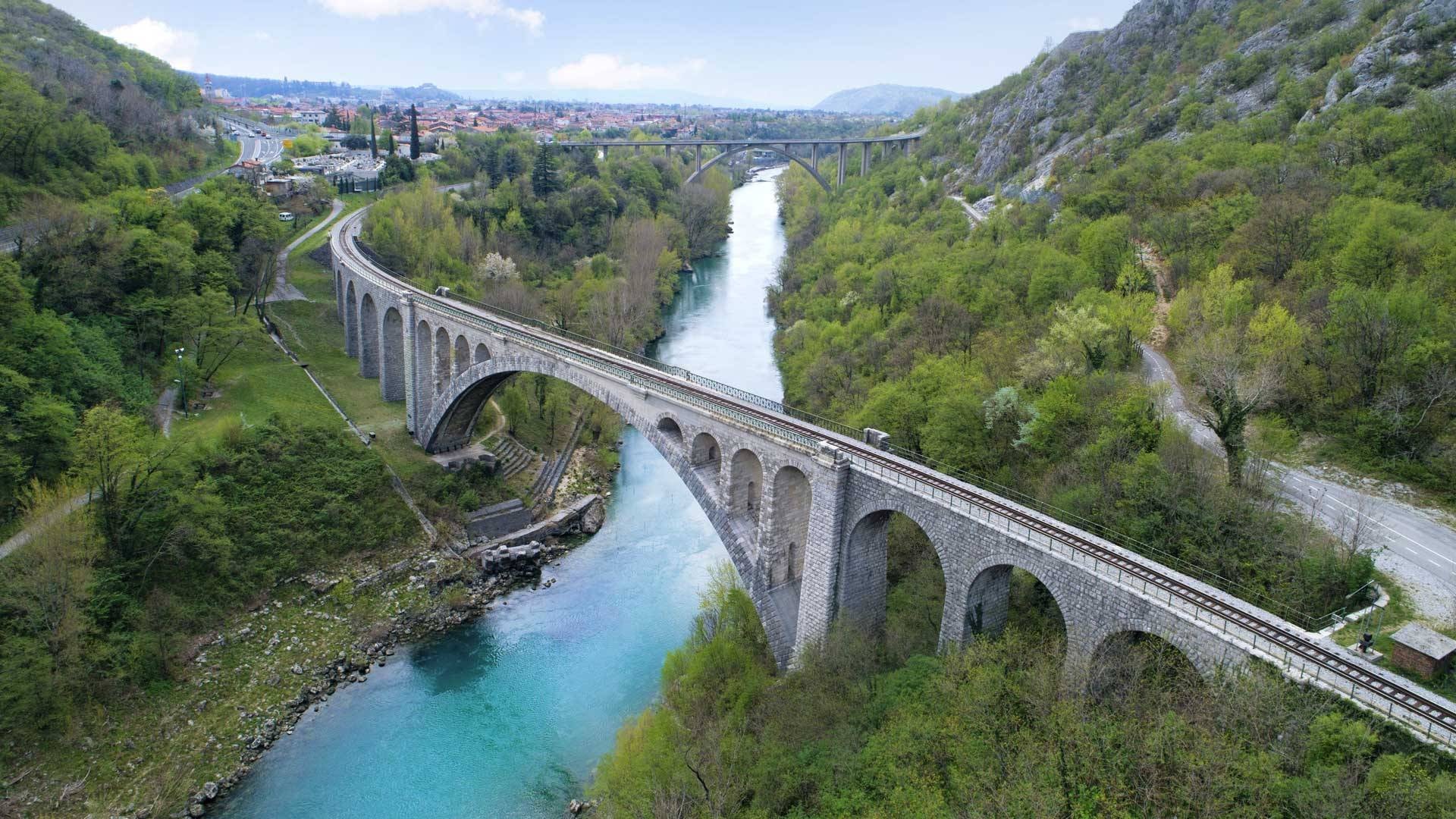 Stone arch railway bridge over the turquoise Soča River in Solkan, Slovenia.