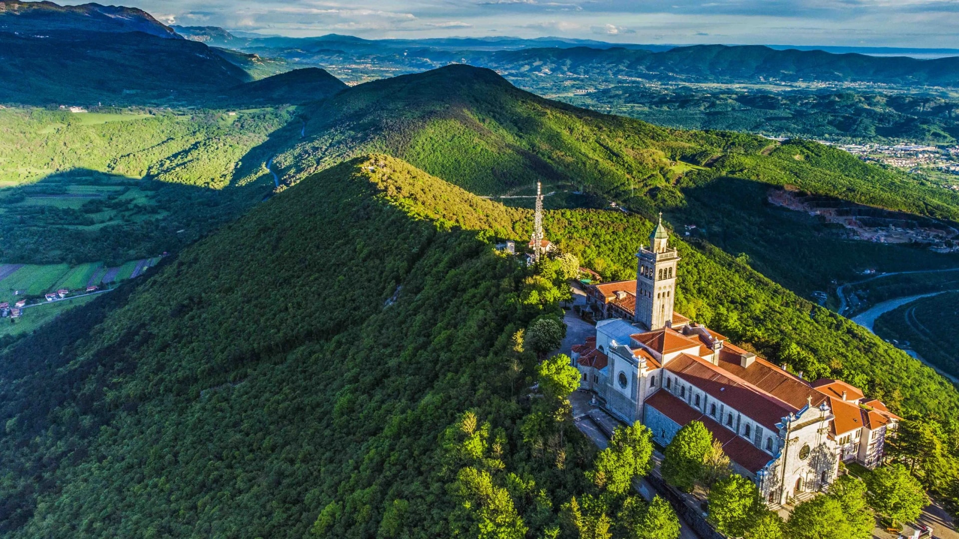 Sveta Gora Monastery perched on a forested mountain ridge overlooking the Vipava Valley.