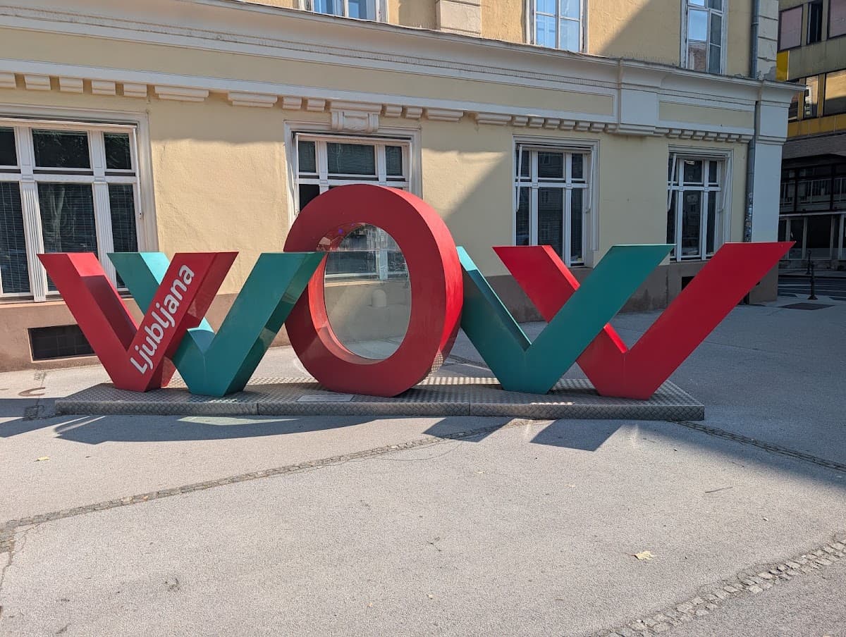 Ljubljana WOW sculpture in front of a yellow building