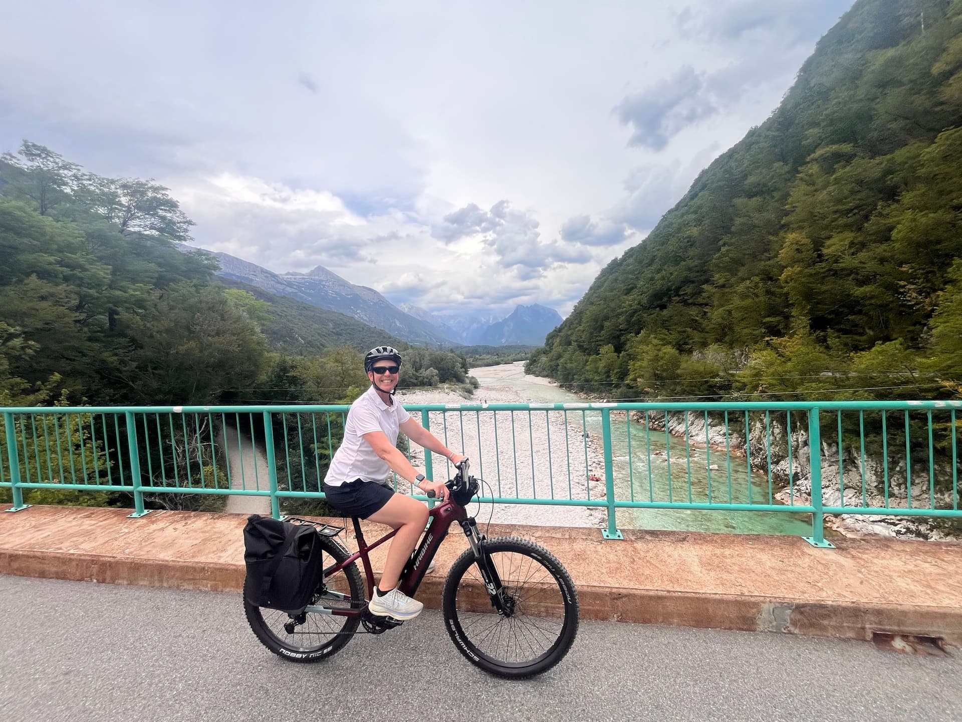Cyclist on a bridge over the Soča river in mountain valley