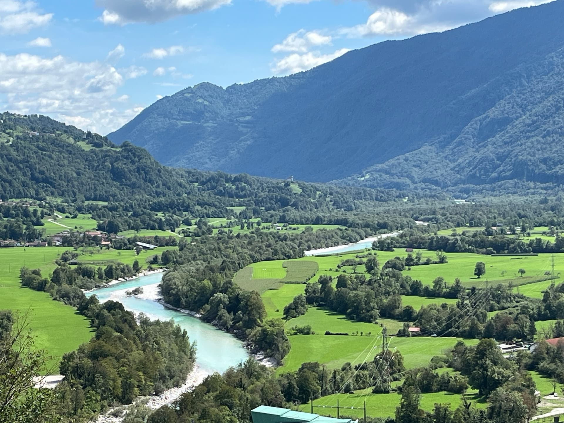 Soča River winding through green valley with surrounding mountains in Slovenia