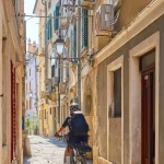 vacker äldre kvinna som cyklar i centrala Piran vid Adriatiska havet i Slovenien, Europa