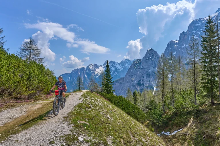 iloinen aktiivinen vanhempi nainen E-maastopyöräretkellä Vršičin solassa Triglavin kansallispuistossa, Julian Alpeilla Kranska Goran yläpuolella Sloveniassa.